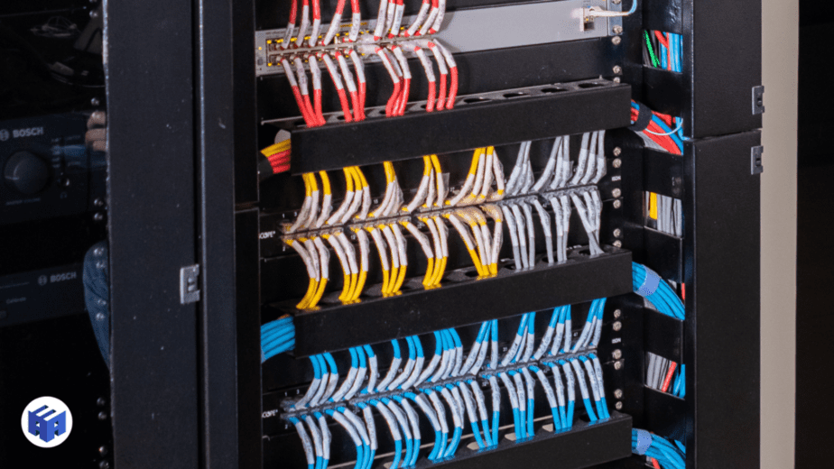 Rack de cabeamento estruturado com organização meticulosa dos cabos e equipamentos de rede.