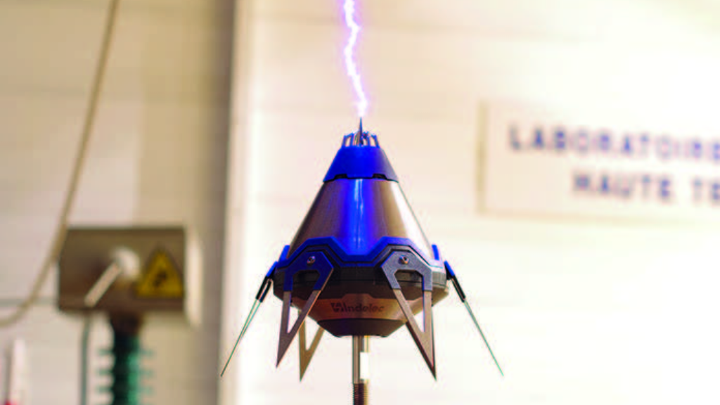 Imagem de um para-raios ionizante, um dispositivo cônico de superfície metálica azul.